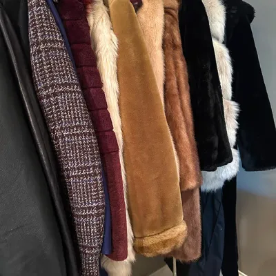 Sale Photo Thumbnail #171: Collection of vintage women's winter coats, including natural fur, faux fur, and wool styles, hanging on a rolling garment rack.