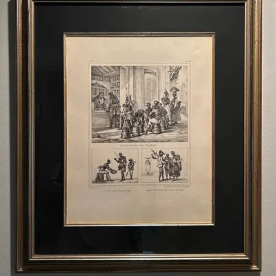 Sale Photo Thumbnail #34: Framed antique French engraved print titled "Marchand de Tabac," presented with a double mat in a gilded wooden frame.
