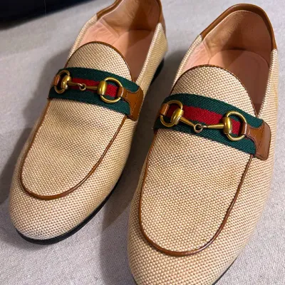 Sale Photo Thumbnail #156: Pair of Gucci horsebit loafers featuring beige canvas uppers, brown leather trim, and classic green and red web stripe details.