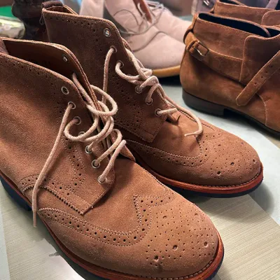 Sale Photo Thumbnail #158: Collection of men's suede boots, featuring a pair of tan wingtip brogue lace-up boots alongside buckle and chukka styles.