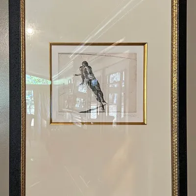 Sale Photo Thumbnail #125: Framed and matted pencil sketch print depicting a figure in motion, presented in a black outer frame with gilt accents and double matting.