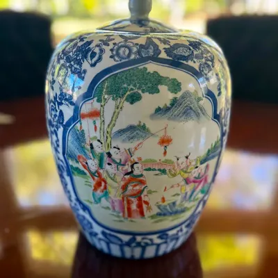 Sale Photo Thumbnail #139: Chinese porcelain ginger jar with lid, featuring hand-painted Famille Rose style polychrome scenes framed by blue and white floral borders.