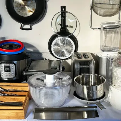 Sale Photo Thumbnail #263: Collection of small kitchen appliances and cookware, including an Instant Pot, toaster, blender, salad spinner, and hanging Le Creuset pans.