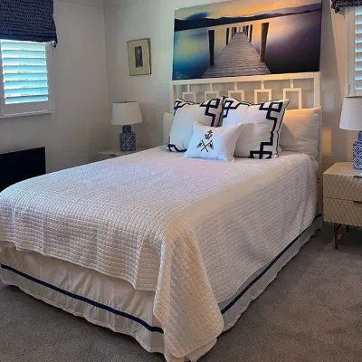 Sale Photo Thumbnail #205: Bedroom suite with white painted fretboard bed frame, matching nightstands, nautical-themed bedding, blue and white lamps, and large wall art.