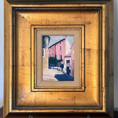 Sale Photo Thumbnail #187: Framed original oil painting depicting a European village street, signed by the artist in the lower left corner and housed in an ornate gilded frame.