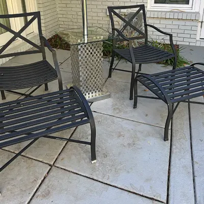 Sale Photo Thumbnail #218: Black metal outdoor seating set including two armchairs with X-back design, two matching slatted ottomans, and a glass-top side table.