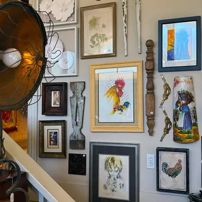 Sale Photo Thumbnail #300: Eclectic gallery wall display featuring framed artwork, botanical prints, rooster paintings, and architectural wood decor pieces.
