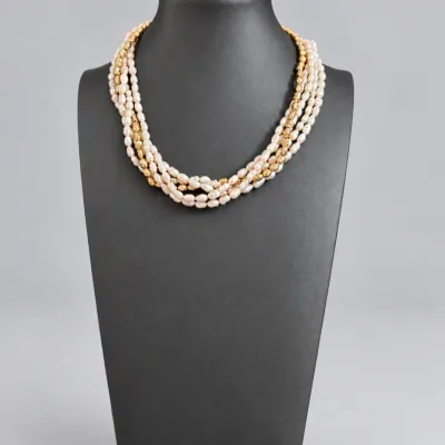 Sale Photo Thumbnail #83: Multi-strand freshwater pearl necklace with textured gold-tone accent beads displayed on a black bust form.