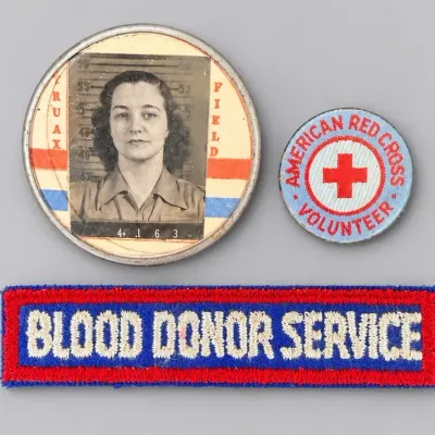 Sale Photo Thumbnail #14: Vintage WWII-era Truax Field photo ID badge alongside an American Red Cross Volunteer pin and a Blood Donor Service embroidered patch.