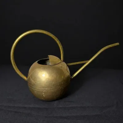 Sale Photo Thumbnail #28: Vintage mid-century brass watering can featuring a spherical body, long slender spout, and large arched handle.