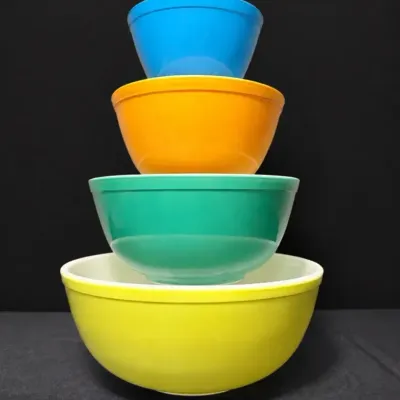 Sale Photo Thumbnail #29: Vintage Pyrex Primary Colors four-piece mixing bowl set stacked in a tower, including blue #401, orange/red #402, green #403, and yellow #404 bowls.
