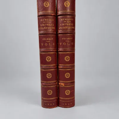 Sale Photo Thumbnail #81: Two-volume set of "Memoirs of the Empress Josephine" by Ducrest, published in 1894 with gilt-embossed reddish-brown leather bindings.