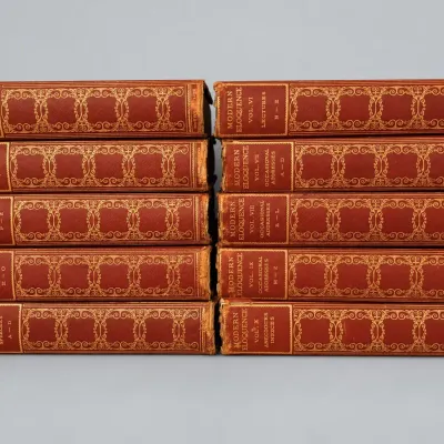 Sale Photo Thumbnail #41: Ten-volume vintage book set of Modern Eloquence, featuring reddish-brown covers with ornate gilded spines, showing light shelf wear.