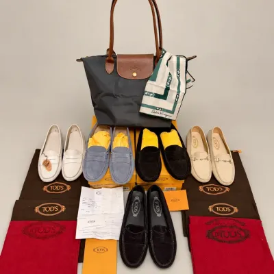 Sale Photo Thumbnail #20: Collection of luxury designer accessories, including multiple pairs of Tod's leather and suede loafers, a Longchamp tote bag, a Salvatore Ferragamo scarf, and original dust bags and boxes.