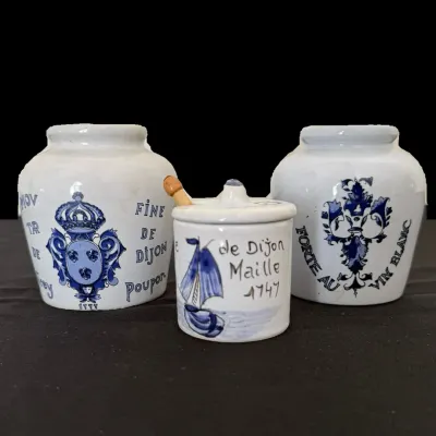 Sale Photo Thumbnail #27: Set of three vintage French blue and white ceramic mustard pots, featuring designs from Grey Poupon and Maille, including one with a lid and small wooden spoon.