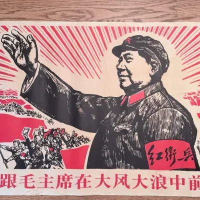 Sale Photo Thumbnail #56: Vintage Chinese Cultural Revolution propaganda poster featuring Mao Zedong waving to a crowd of Red Guards, with bold red and black graphic styling and Chinese typography along the bottom.