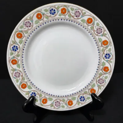 Sale Photo Thumbnail #102: Vintage porcelain decorative plate on a display stand, featuring an intricate floral rim in orange, purple, blue, and green tones.