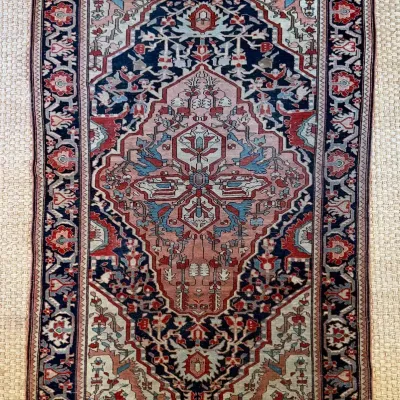 Sale Photo Thumbnail #4: Hand-knotted Persian Heriz-style area rug featuring a central geometric medallion in shades of dusty rose, navy blue, and cream.
