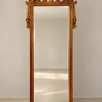 Sale Photo Thumbnail #94: Ornate French Rococo style gilded floor mirror with elaborate cresting and side tassel accents.
