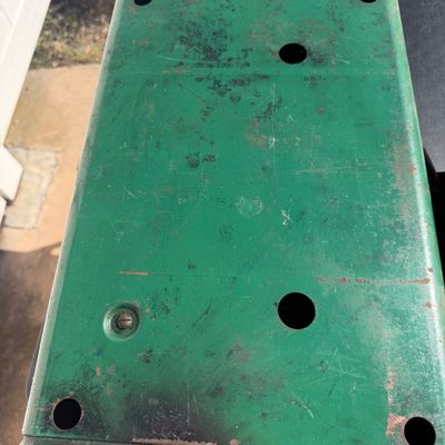Sale Photo Thumbnail #267: Vintage green painted metal base or housing with pre-drilled mounting holes, showing surface wear and minor rust.