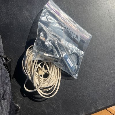 Sale Photo Thumbnail #277: Assorted vintage audio and electronic accessories, including a coiled white cable and a clear plastic bag with connectors and clips.