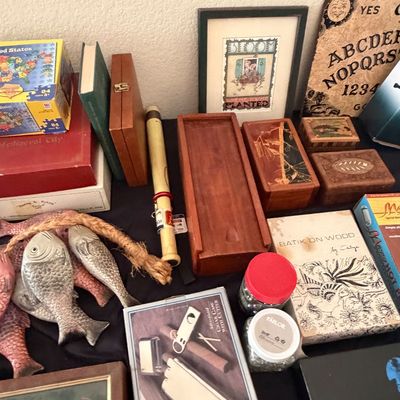 Sale Photo Thumbnail #106: Eclectic tabletop assortment of home decor, including wooden boxes, framed art, novelty fish figures, and a vintage-style Ouija board.