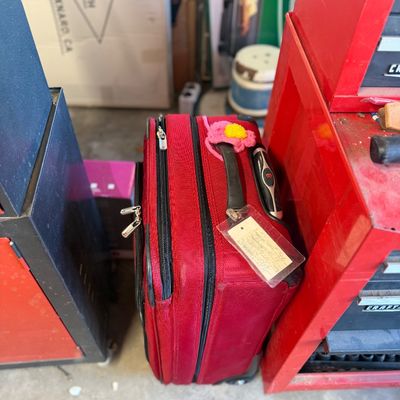 Sale Photo Thumbnail #247: Red Victorinox Swiss Army softside rolling luggage with a luggage tag and pink crocheted flower identifier attached.