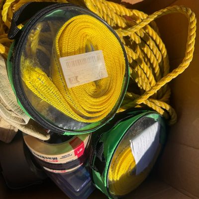 Sale Photo Thumbnail #276: Cardboard box containing bright yellow synthetic rope, coiled tie-down straps in clear zippered cases, and masking tape.