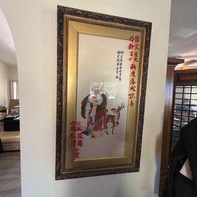 Sale Photo Thumbnail #41: Framed Asian artwork featuring a traditional figure with a deer, calligraphy, and custom red text detailing presented in an ornate gold-tone double frame.
