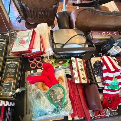 Sale Photo Thumbnail #127: Assortment of household items and holiday décor, including Jack Daniel's tin boxes, a electric panini press grill, a holiday scarf, and novelties.