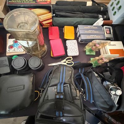 Sale Photo Thumbnail #100: Collection of assorted household and personal items, including camera bags, lenses, small umbrellas, hard-shell card cases, and a sushi maker.