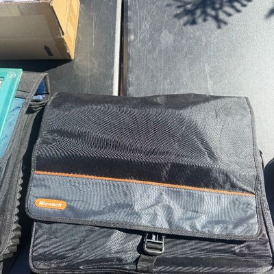 Sale Photo Thumbnail #278: Black nylon Microsoft promotional messenger shoulder bag with orange trim accents, featuring a front flap and buckle closure.
