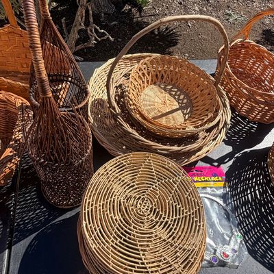 Sale Photo Thumbnail #287: Collection of vintage woven wicker items including round chargers, handled baskets, tall wine bottle holders, and a packaged toy necklace.