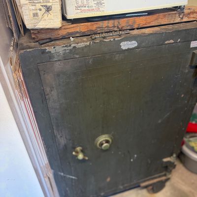 Sale Photo Thumbnail #205: Vintage heavy-duty steel combination floor safe on wheels, showing significant surface wear and patina.