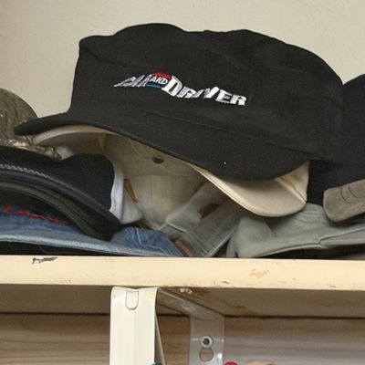Sale Photo Thumbnail #175: Vintage black and cream Car and Driver embroidered cap resting on a closet shelf among other hats.