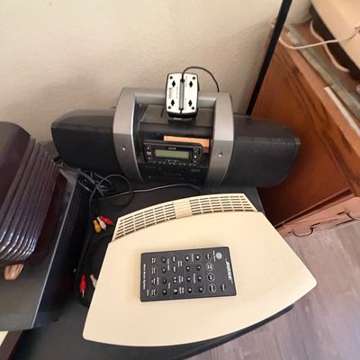 Sale Photo Thumbnail #99: Bose Wave Music System with original remote control alongside a black portable boombox with an attached Sirius satellite radio receiver module.