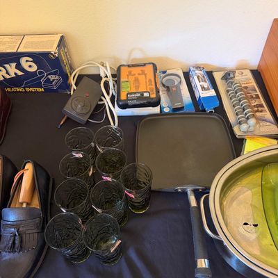 Sale Photo Thumbnail #323: Assortment of household goods, including green textured glassware, a stovetop griddle, men's leather shoes, electronics, and small kitchenware items.