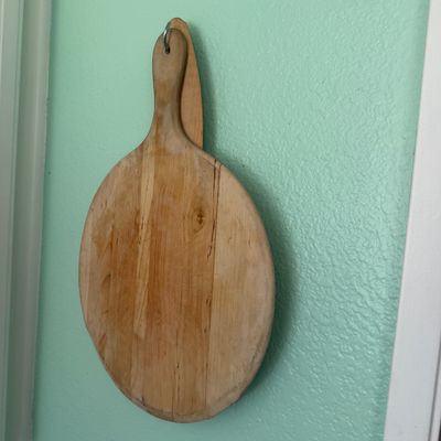 Sale Photo Thumbnail #16: Vintage round wooden cutting board with handle, showing light wear and natural wood grain.