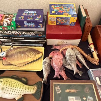 Sale Photo Thumbnail #107: Collection of games, puzzles, and fishing-themed decor, including a Big Mouth Billy Bass singing fish, stringer of decorative fish, and framed fishing shadowbox.