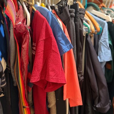 Sale Photo Thumbnail #183: Selection of casual clothing including t-shirts and jackets hanging in a closet.