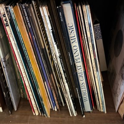 Sale Photo Thumbnail #30: Collection of vintage 33 RPM vinyl LP records stored upright in a wooden shelf unit, featuring various mid-20th century pop, soundtrack, and holiday albums.