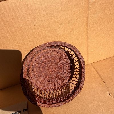 Sale Photo Thumbnail #282: Round dark stain wicker basket featuring a braided rim and an open-weave lattice side design.