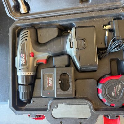 Sale Photo Thumbnail #242: Task Force cordless drill set in a black molded carrying case, including battery pack, charger base, AC adapter, and tape measure.