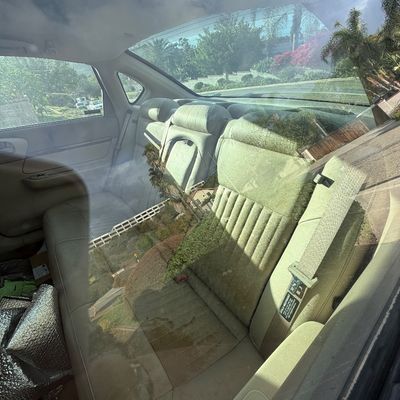 Sale Photo Thumbnail #7: Interior view of a sedan's rear bench seat with beige cloth upholstery, viewed through a window.