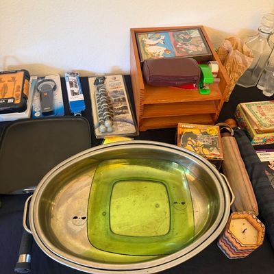 Sale Photo Thumbnail #322: Assortment of household items including stainless steel roasters, green glass dishware, packaged electronics accessories, and wooden desktop storage.