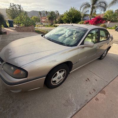Sale Photo Thumbnail #4: Gold Chevrolet Impala sedan, circa early 2000s, parked on a residential driveway.