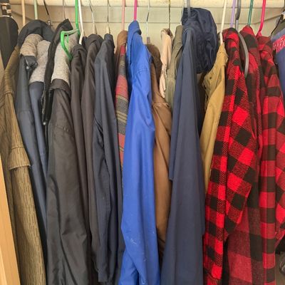 Sale Photo Thumbnail #23: Collection of men's outerwear, including red buffalo plaid jackets, windbreakers, and heavy coats hanging in a closet.