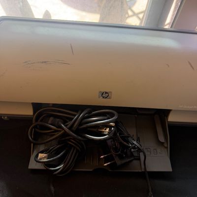 Sale Photo Thumbnail #311: HP Deskjet D1600 series printer with power adapter and USB connecting cables, showing light scuff marks on top body.