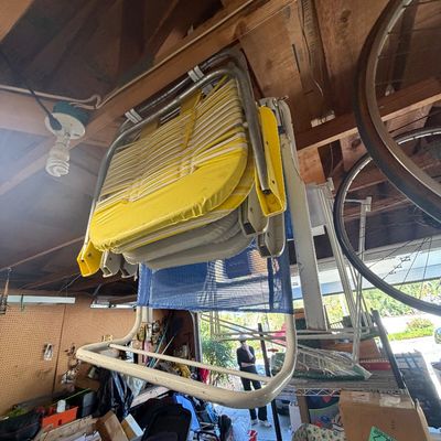 Sale Photo Thumbnail #43: Vintage folding lawn chairs hanging from rafters in a garage, featuring yellow vinyl padding and mesh seating.
