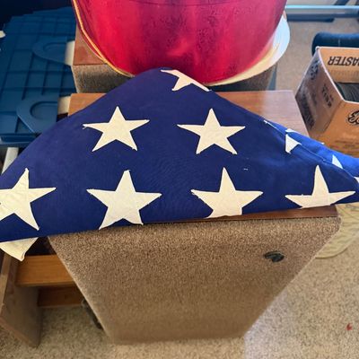 Sale Photo Thumbnail #164: Ceremonially folded American flag resting on top of a vintage wooden floor speaker with a fabric grille.